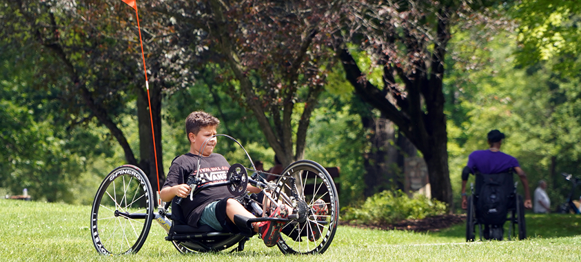 An Adaptive bike rider at Independence Oaks County Park enjoying a summer day.