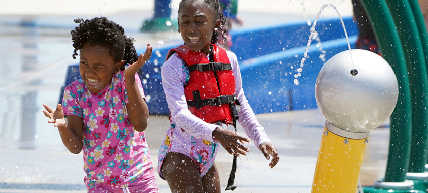 two children playing at the red oaks waterpark splash pad